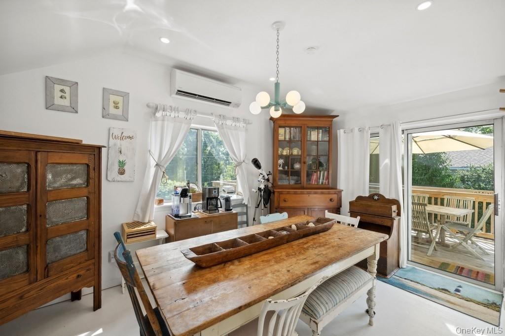 Dining area with healthy amount of natural light, a chandelier, a wall mounted air conditioner, and recessed lighting