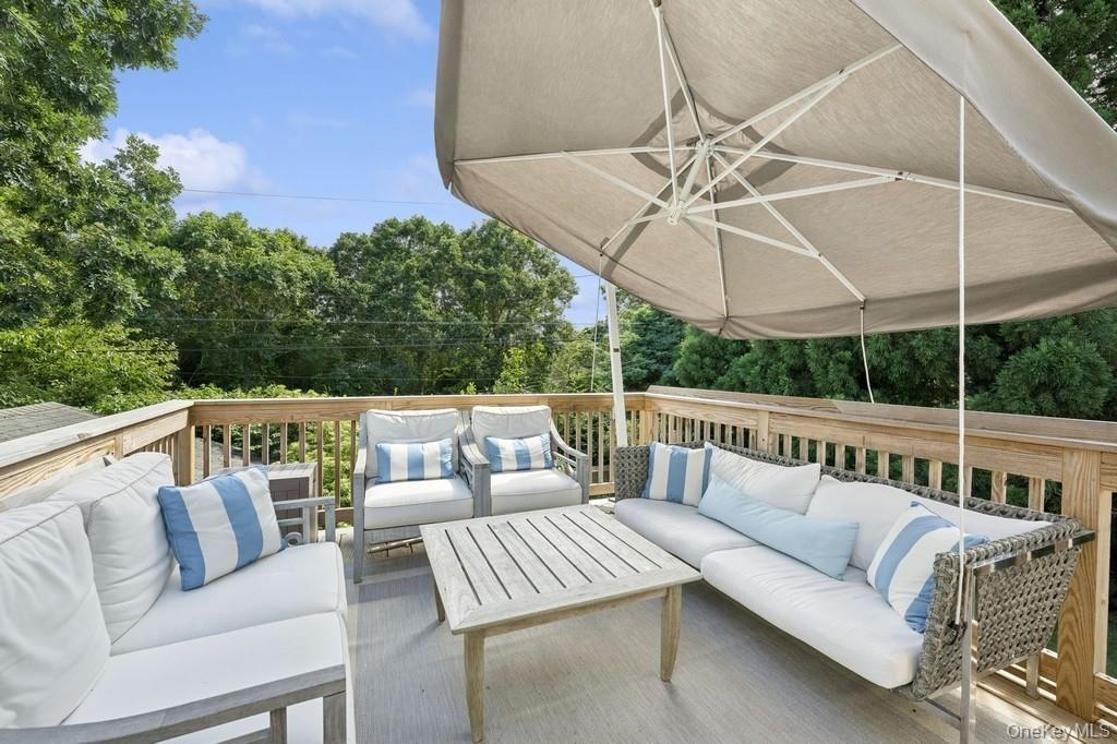 Wooden terrace with outdoor lounge area and view of scattered trees