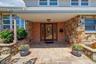 Entrance to property featuring stone siding and a patio area