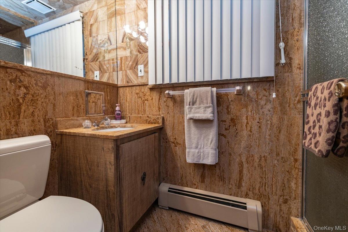 Bathroom with vanity, and a stall shower.