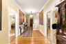 Corridor featuring light wood-style flooring, ornamental molding, and stairs