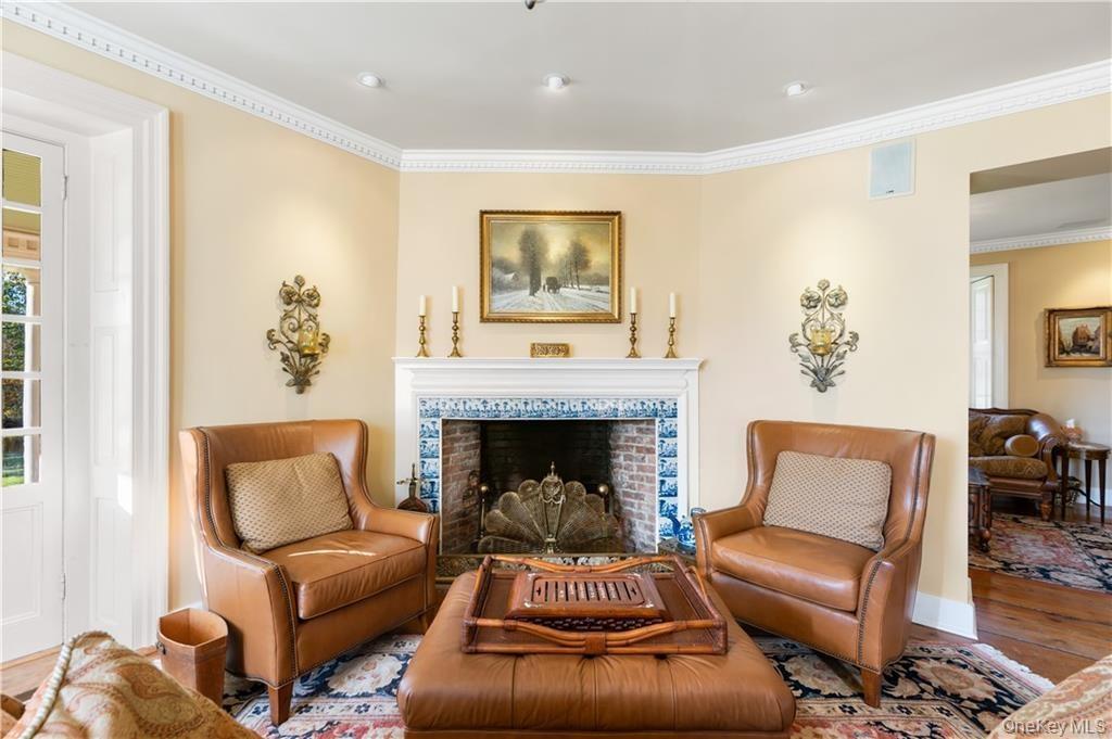 Living area featuring ornamental molding, wood finished floors, and a fireplace