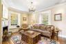 Living area featuring a chandelier, hardwood / wood-style flooring, ornamental molding, and a fireplace