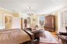 Bedroom featuring a chandelier, light wood-style floors, and crown molding