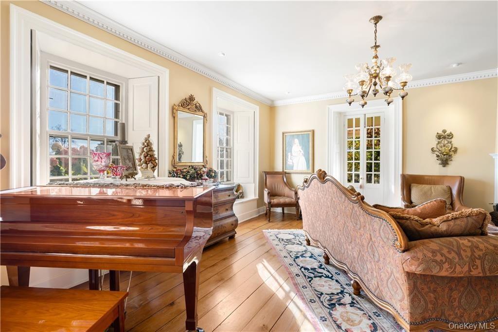 Living area with a chandelier, light wood-style floors, and ornamental molding