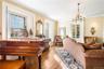 Living area with a chandelier, light wood-style floors, and ornamental molding