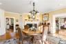 Dining room with a chandelier, light wood-type flooring, ornamental molding, and a fireplace