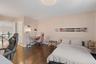 Bedroom with an office area, dark wood finished floors, a chandelier, and ensuite bathroom