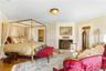 Bedroom with crown molding, a fireplace, and wood finished floors