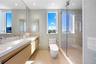 Bathroom featuring tile walls, vanity, a shower stall, and dark aggregate flooring