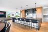 Kitchen with modern cabinets, a breakfast bar, decorative light fixtures, a large island, and light wood finished floors