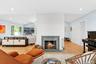 Living area featuring lofted ceiling, recessed lighting, light wood finished floors, and a brick fireplace