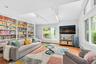 Living room with track lighting, healthy amount of natural light, and wood finished floors