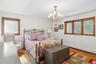 Bedroom with wood finished floors, a baseboard radiator, and a chandelier