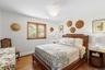 Bedroom with wood finished floors, baseboard heating, and a chandelier