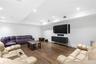 Living room with recessed lighting, wood finished floors, and a raised ceiling