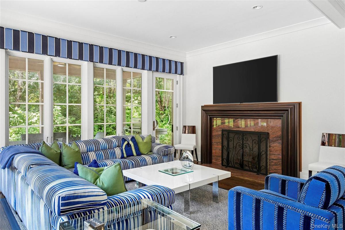 Living room featuring a fireplace, dark wood-style flooring, and ornamental molding