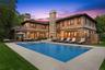 Back of property with a patio area, a chimney, a pool with connected hot tub, and an outdoor living space
