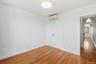 Unfurnished bedroom with light wood-style flooring, a closet, and an AC wall unit