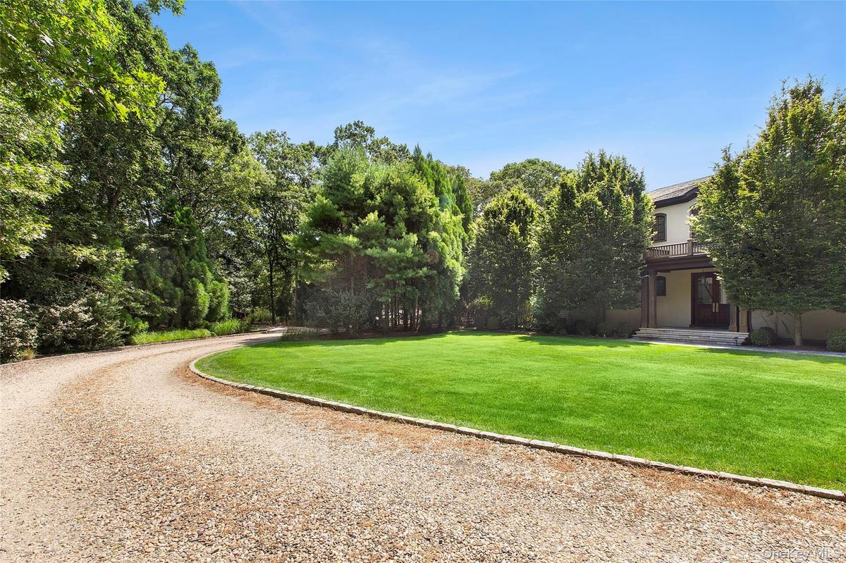 View of home's community featuring a lawn and driveway