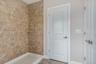 Bathroom with baseboards and a tile shower