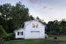 View of property exterior featuring a garage and asphalt driveway