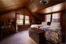 Carpeted bedroom with lofted ceiling, a baseboard heating unit, cooling unit, and wooden walls