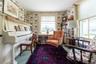 Living area with wallpapered walls and carpet flooring