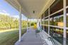 Wooden porch featuring a water view, a yard, and view of wooded area