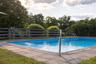 View of pool with view of wooded area