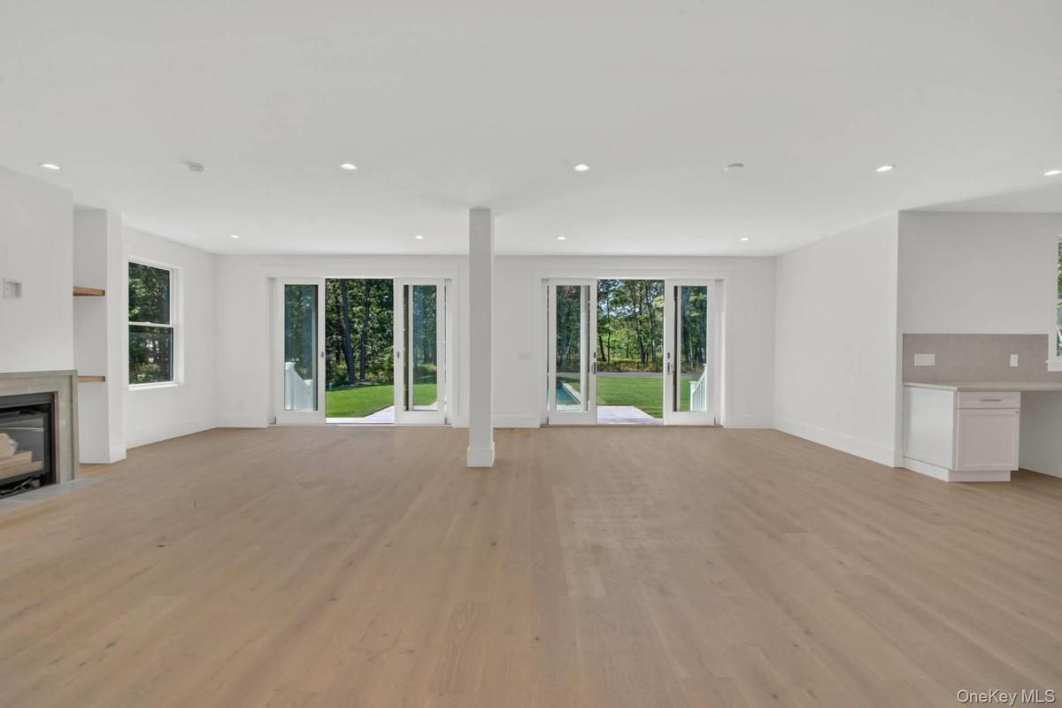 Unfurnished living room featuring healthy amount of natural light, light wood-style flooring, recessed lighting, and a fireplace