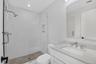 Bathroom with a stall shower, vanity, tile walls, and recessed lighting