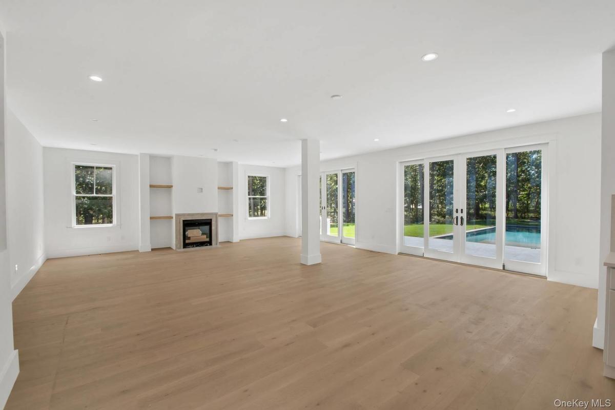Unfurnished living room with light wood-type flooring, french doors, recessed lighting, and a fireplace