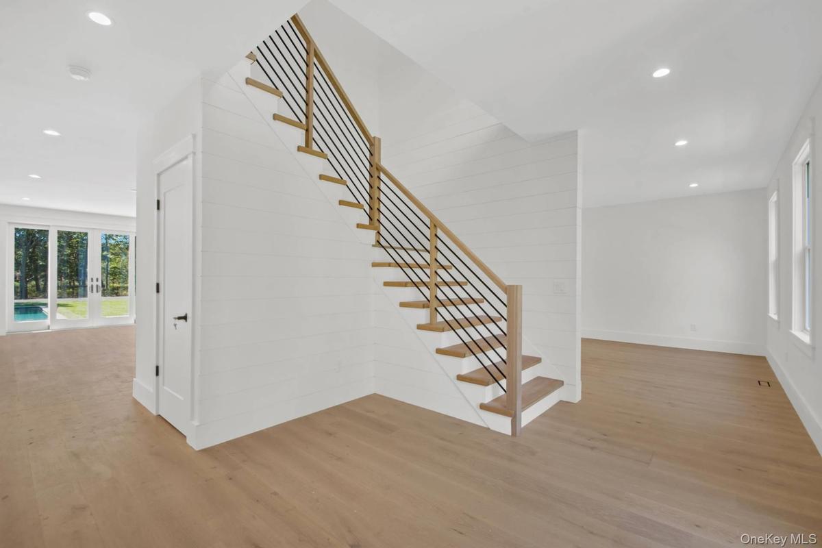 Stairway with recessed lighting and wood finished floors