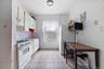 Kitchen featuring white appliances, white cabinets, light countertops, tasteful backsplash, and light tile patterned floors