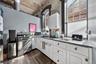Kitchen featuring white cabinets, dark wood-style floors, healthy amount of natural light, stainless steel range with gas stovetop, and a high ceiling