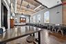 Dining space with a towering ceiling and dark wood-style flooring
