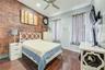 Bedroom featuring dark wood finished floors, brick wall, and baseboards