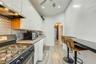 Kitchen with extractor fan, washer / dryer, stainless steel appliances, arched walkways, and white cabinetry