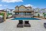 Back of property with a fenced in pool and a patio