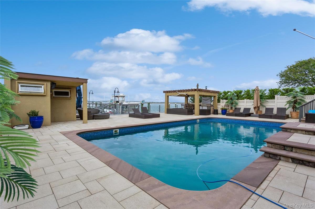 View of pool with a patio, a water view, and a pergola