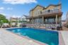Back of property with a patio area, a fenced in pool, and a balcony