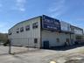 View of building exterior with fence and cooling unit