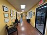 Corridor with wood finished floors, a paneled ceiling, and baseboards