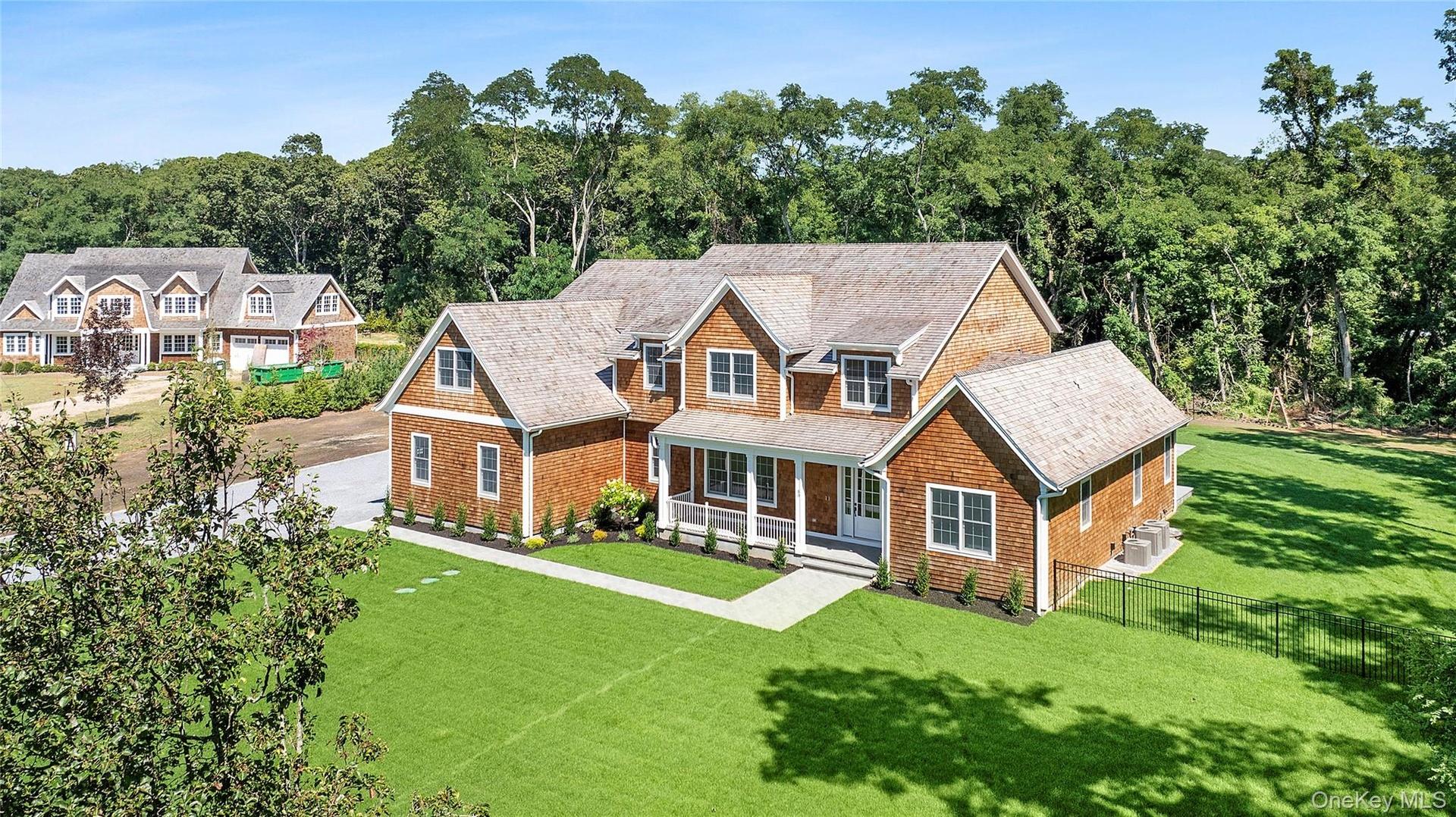 Shingle-style home featuring a porch and roof with shingles
