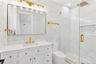 Full bathroom featuring a marble finish shower, vanity, tile walls, and recessed lighting