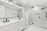 Bathroom featuring a stall shower and double vanity