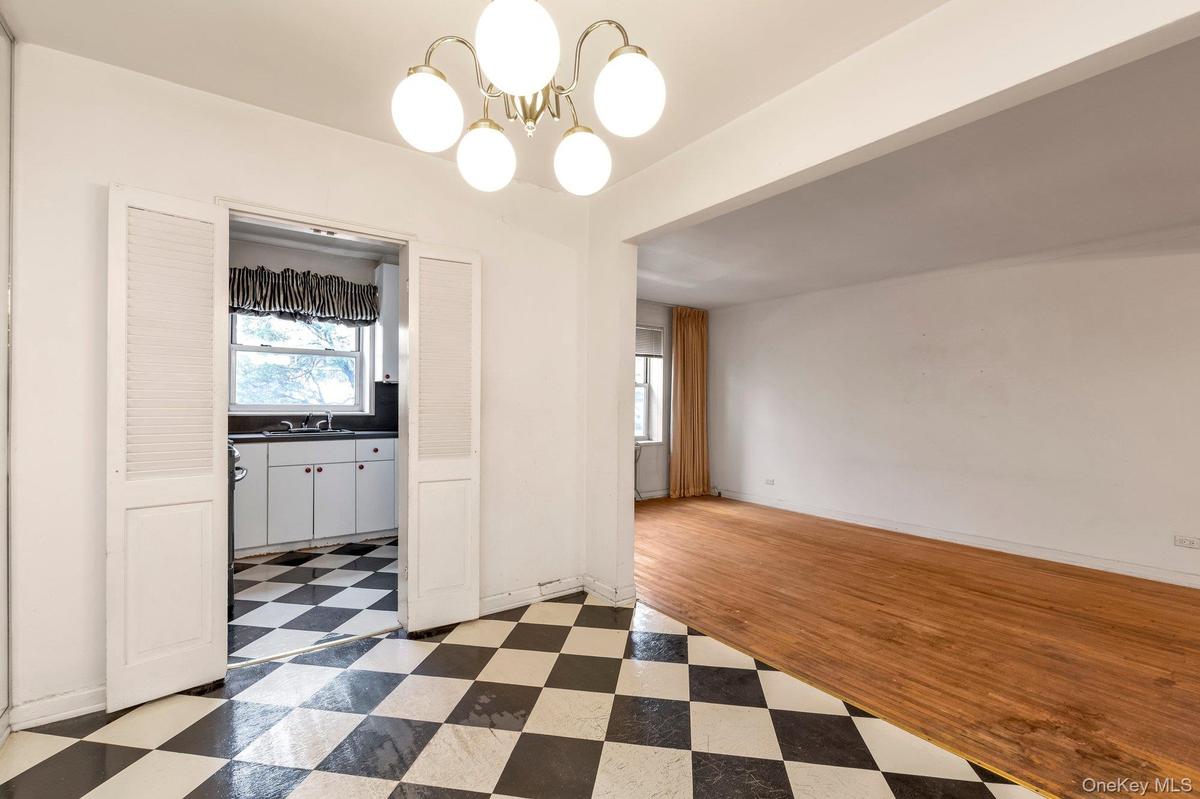 Unfurnished dining area featuring light flooring and a chandelier