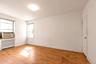 Unfurnished room with radiator heating unit, light wood-style flooring, and cooling unit