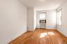 Spare room featuring light wood-style floors and radiator heating unit